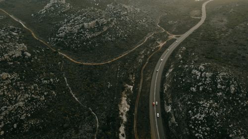 Free Aerial view of a winding road through rocky mountains, captured during dusk. Stock Photo