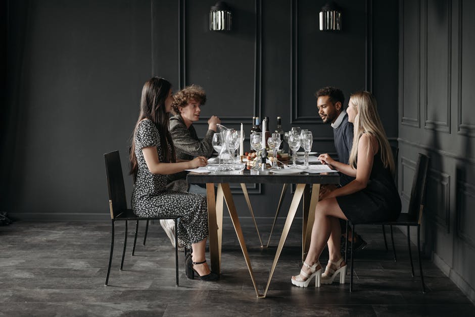 A diverse group of people sitting around a table, laughing and enjoying a meal together in a modern restaurant setting.