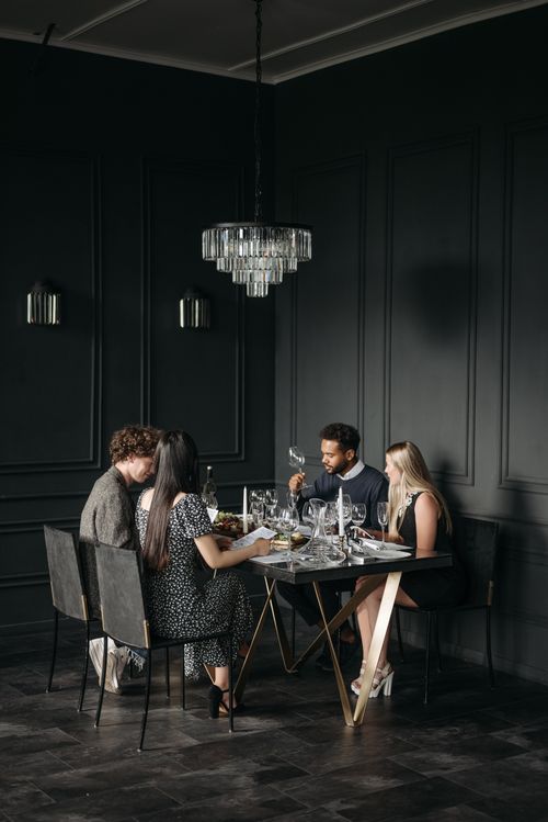 Free A group of adults enjoying a sophisticated wine tasting dinner indoors in an elegant modern setting. Stock Photo