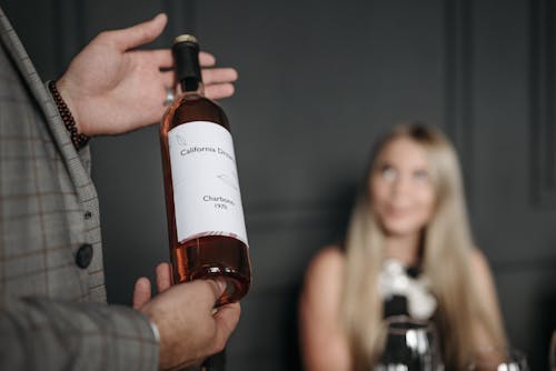Free A Person Holding a Wine Bottle Stock Photo