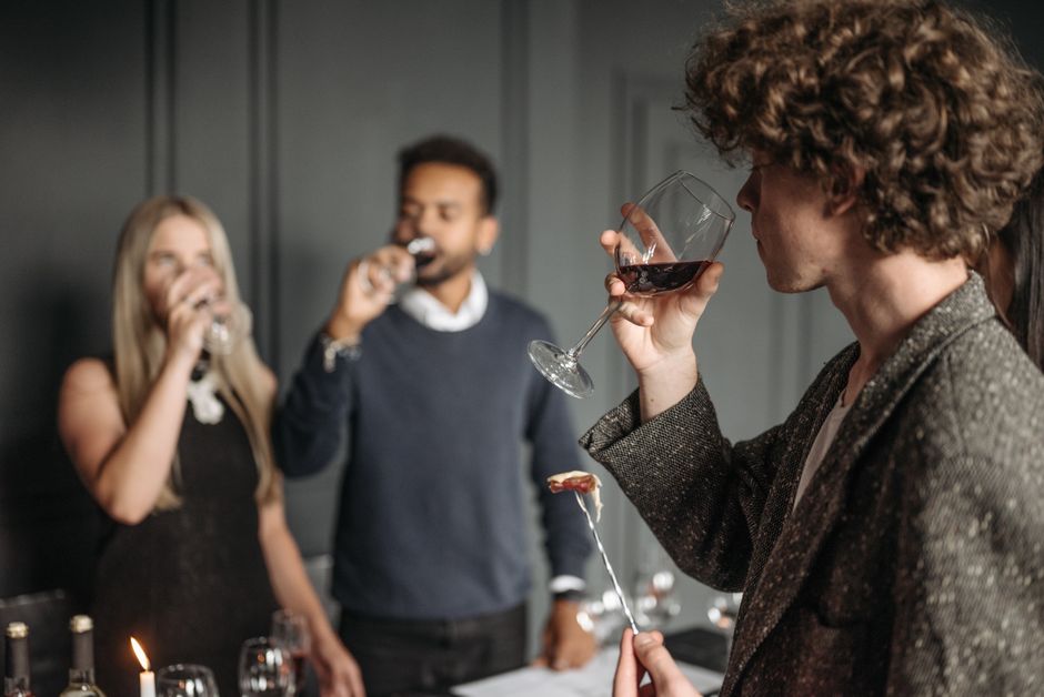 A group tasting wine together, sipping from glasses
