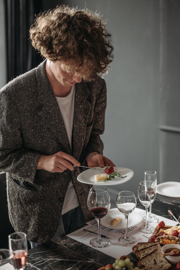 Person In Brown Coat Putting Food On A Plate