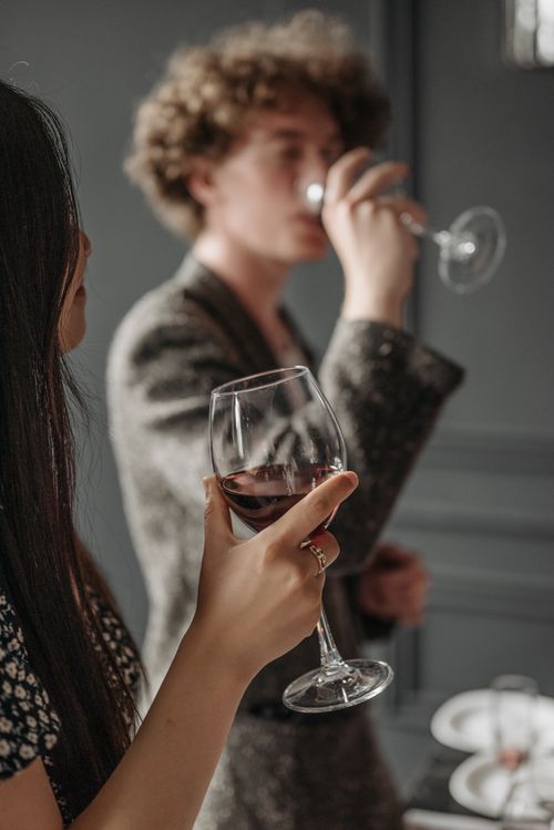 Free Young adults enjoying red wine in an intimate indoor setting, captured with elegance. Stock Photo
