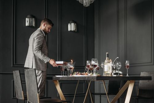 Free A sommelier preparing a wine tasting table with bottles and glasses in a stylish interior. Stock Photo