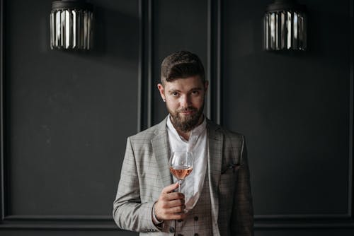 Man in Gray Blazer Holding a Glass of Wine