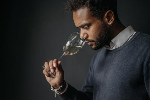 Close-Up Shot of a Bearded Man Smelling His Drink