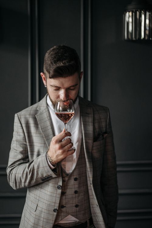 Free Elegantly dressed man savoring wine with a contemplative expression. Stock Photo