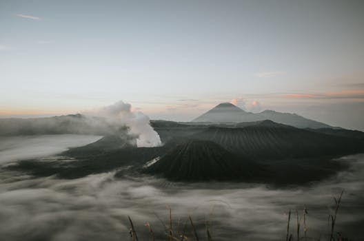 Scenic sunrise view of Mount Bromo with mist and volcanic steam in East Java, Indonesia.