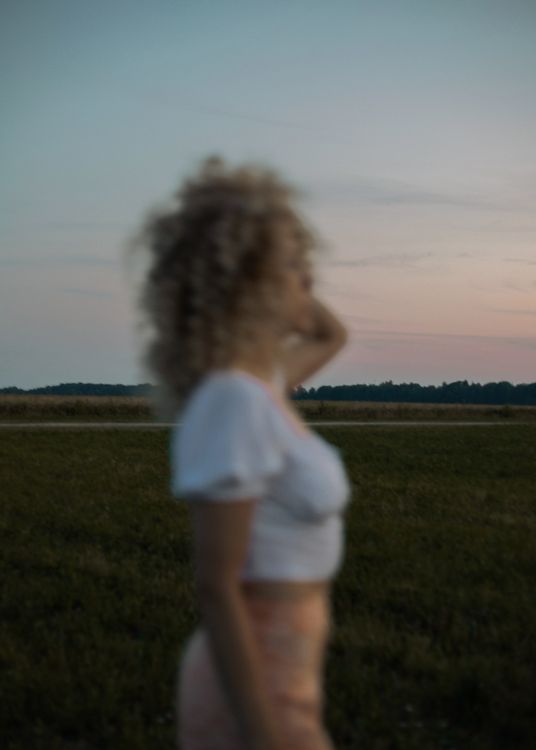 Woman in White Shirt Standing on Green Grass Field · Free Stock Photo