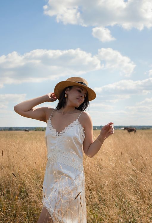 Woman in a Dress and a Hat Standing in a Field · Free Stock Photo