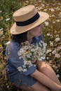 Woman in Blue and White Pin Stripe Dress Sitting on Grass Field