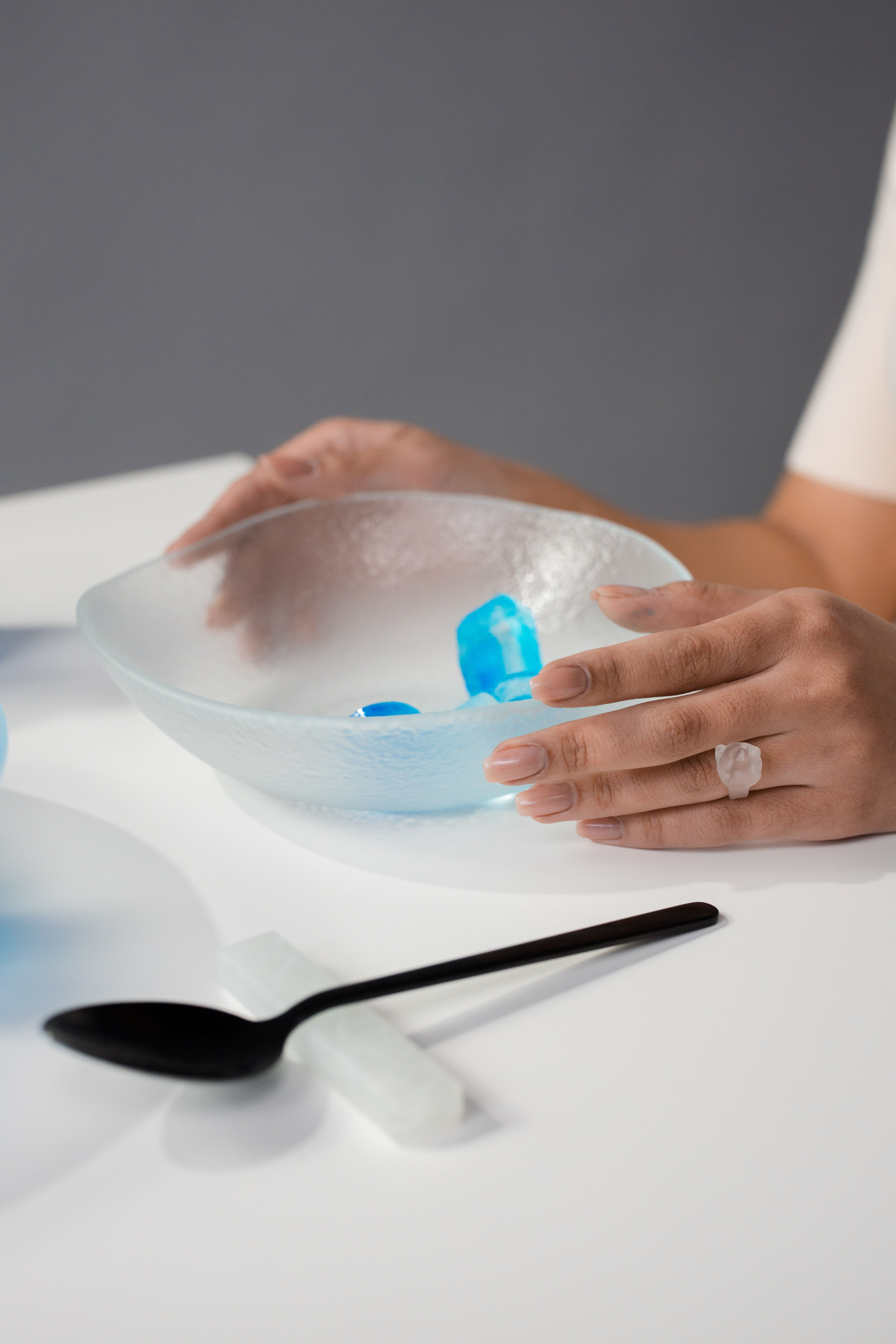 Persons Hand on Blue and White Plastic Container · Free Stock Photo