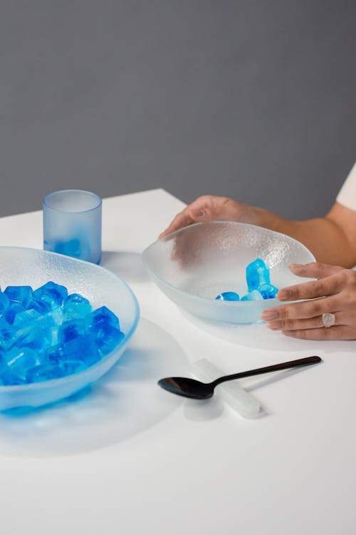 Person, Die Edelstahllöffel Und Blaue Keramikschüssel Mit Blauer Und Weißer Runder Keramikschüssel Hält