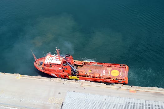 An aerial perspective of a vibrant red industrial ship docked at a harbor, emphasizing maritime operations.