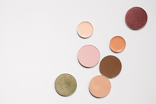 A collection of colorful eyeshadows displayed on a white surface, ideal for beauty and makeup themes.