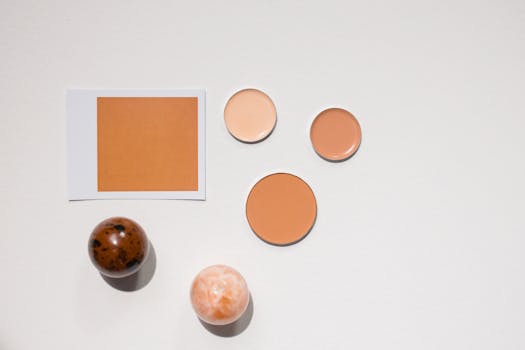 A clean, minimalist flat lay showcasing diverse cosmetics shades on a white surface.