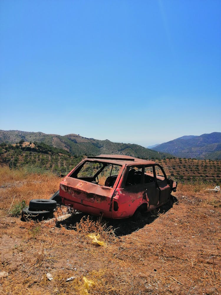 An Abandoned Car On The Field