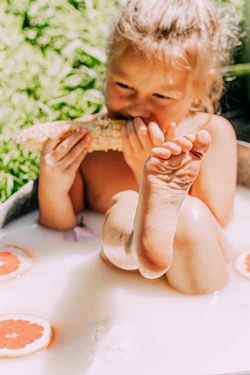 A Young Girl Eating a Corn