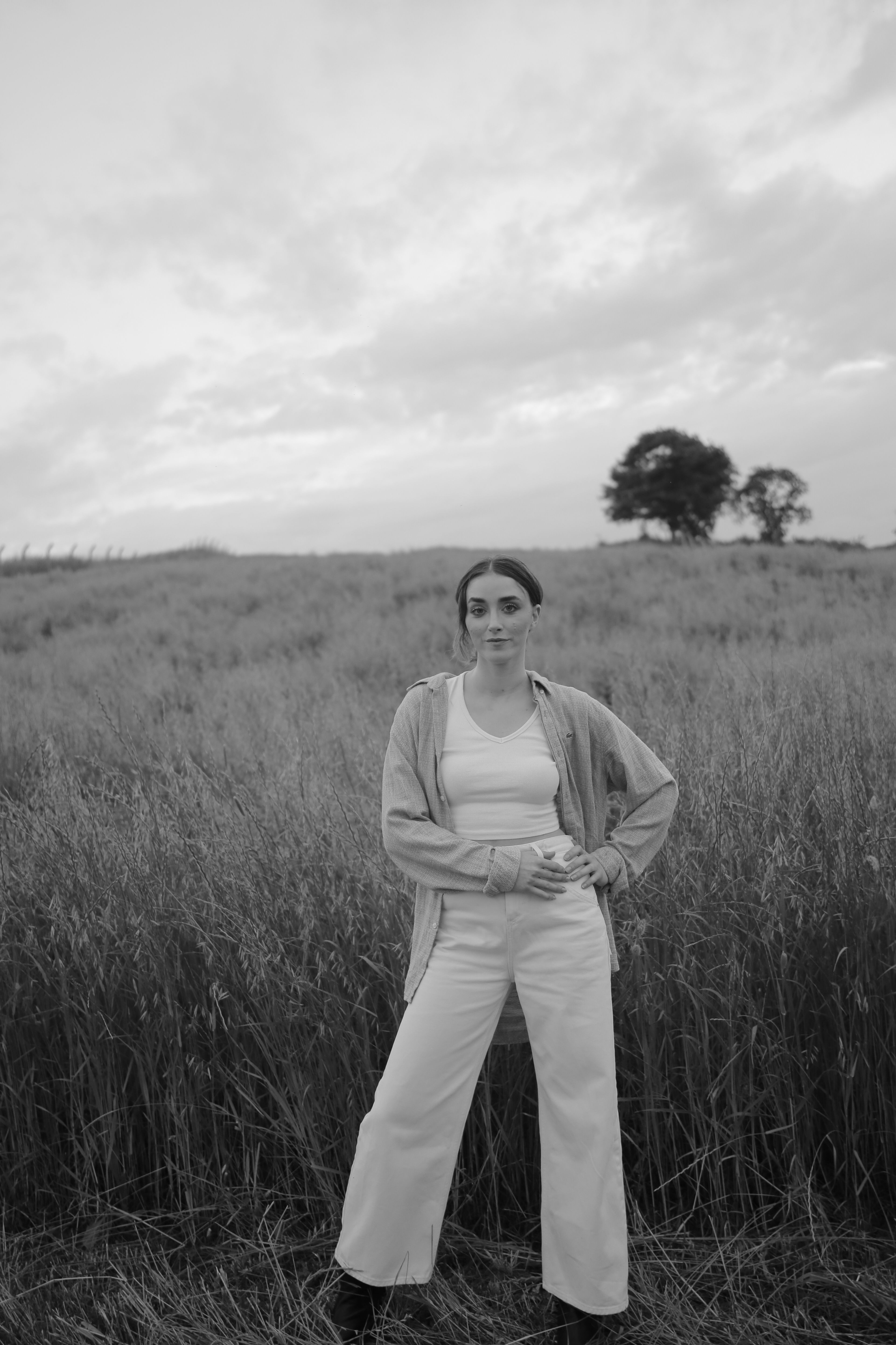 Grayscale Photo of a Woman in Black Dress Posing on a Grassy Field ...