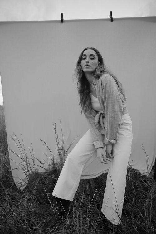 Free Elegant woman posing in an outdoor fashion shoot with a monochrome backdrop. Stock Photo