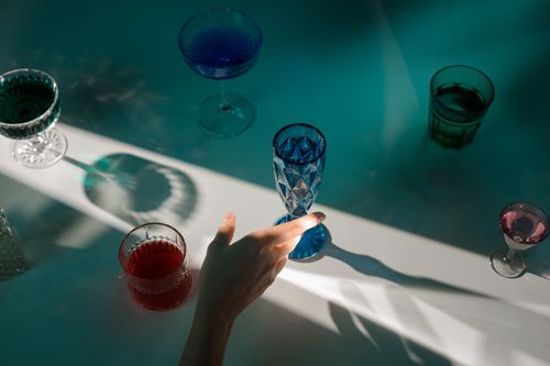 Free A minimalist still life featuring colorful drinks in elegant glassware with dramatic lighting. Stock Photo