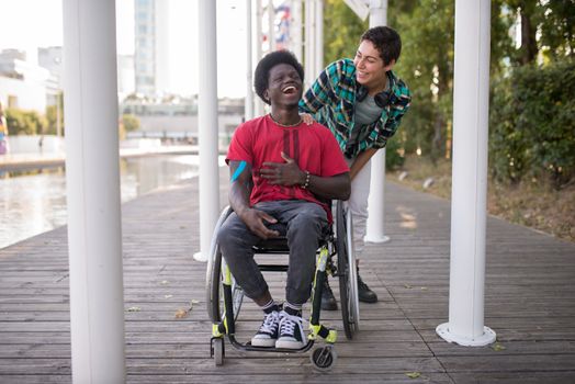 Two friends, one in a wheelchair, sharing a joyful moment outdoors in Portugal.