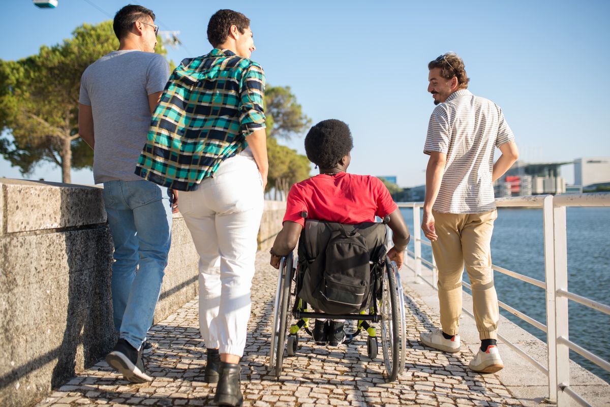 A diverse group of people with disabilities enjoying an outdoor activity together.