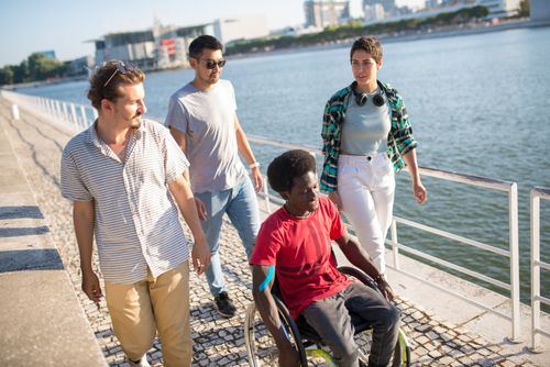 Free A diverse group of friends enjoys a sunny day by the waterfront, highlighting inclusion and friendship. Stock Photo