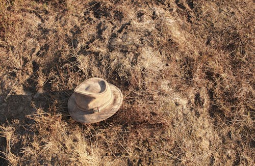 Beige Hat on a Dust and Gray Grass