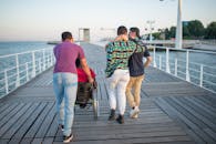 一群朋友沿着海边风景优美的木板路上行走，促进友谊和交通便利