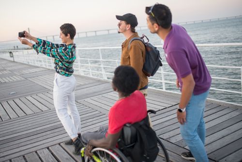 Free A diverse group of friends enjoying a sunny day on a pier in Portugal, capturing memories with a selfie. Stock Photo