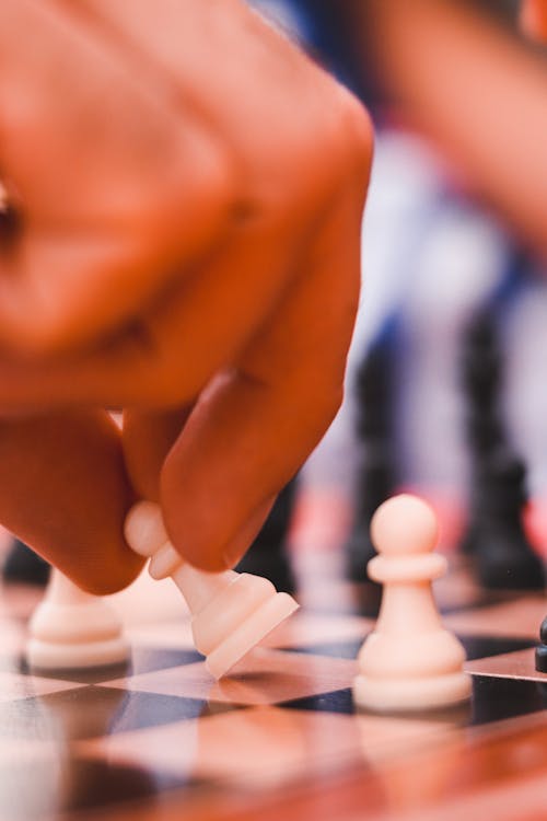 A Person Holding White Chess Piece