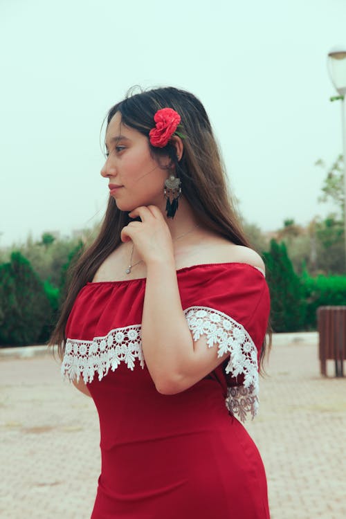 Woman in Red Off Shoulder Dress with Flower on Her Hair