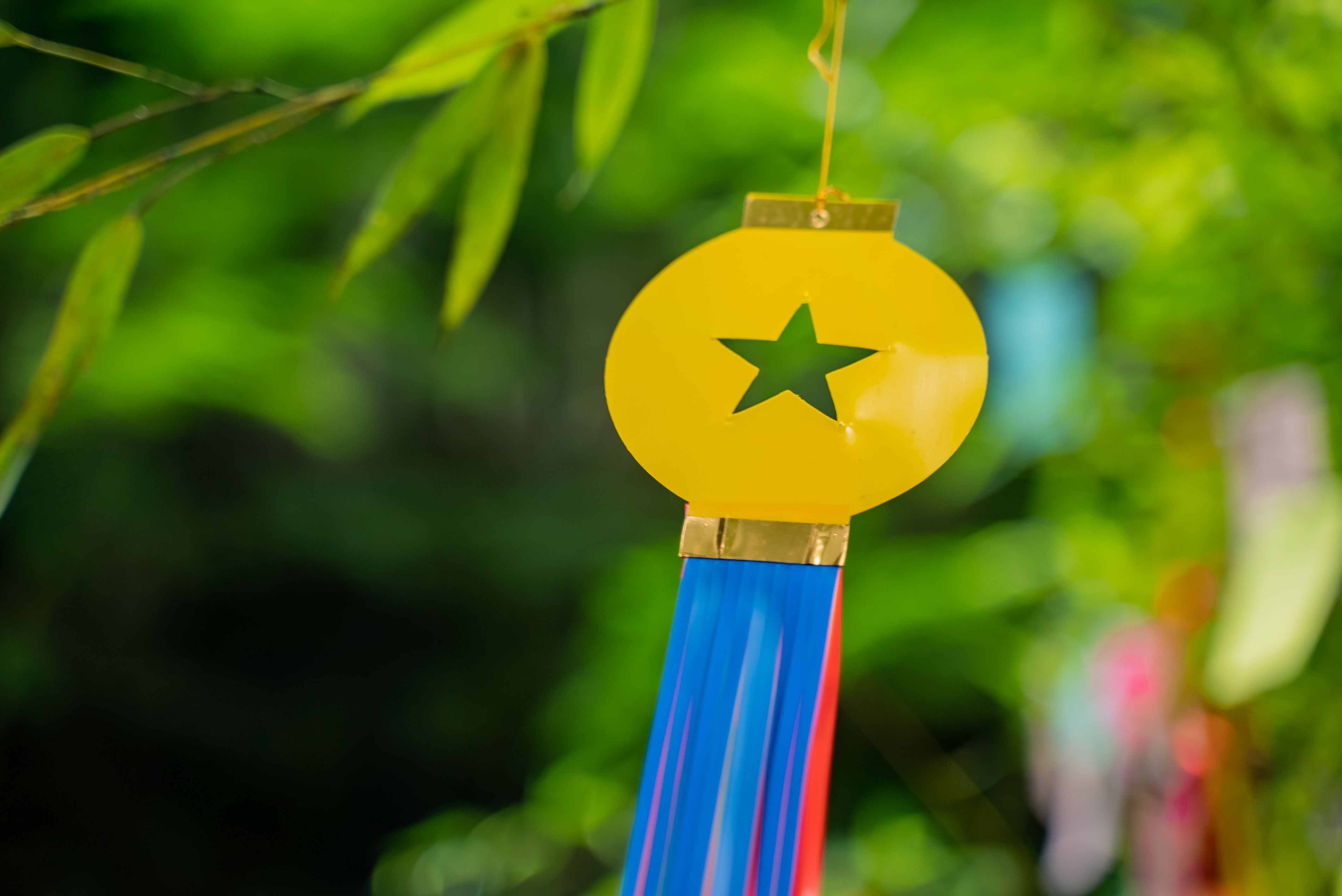 Close-up of a colorful star ornament hanging outdoors, evoking a festive mood.