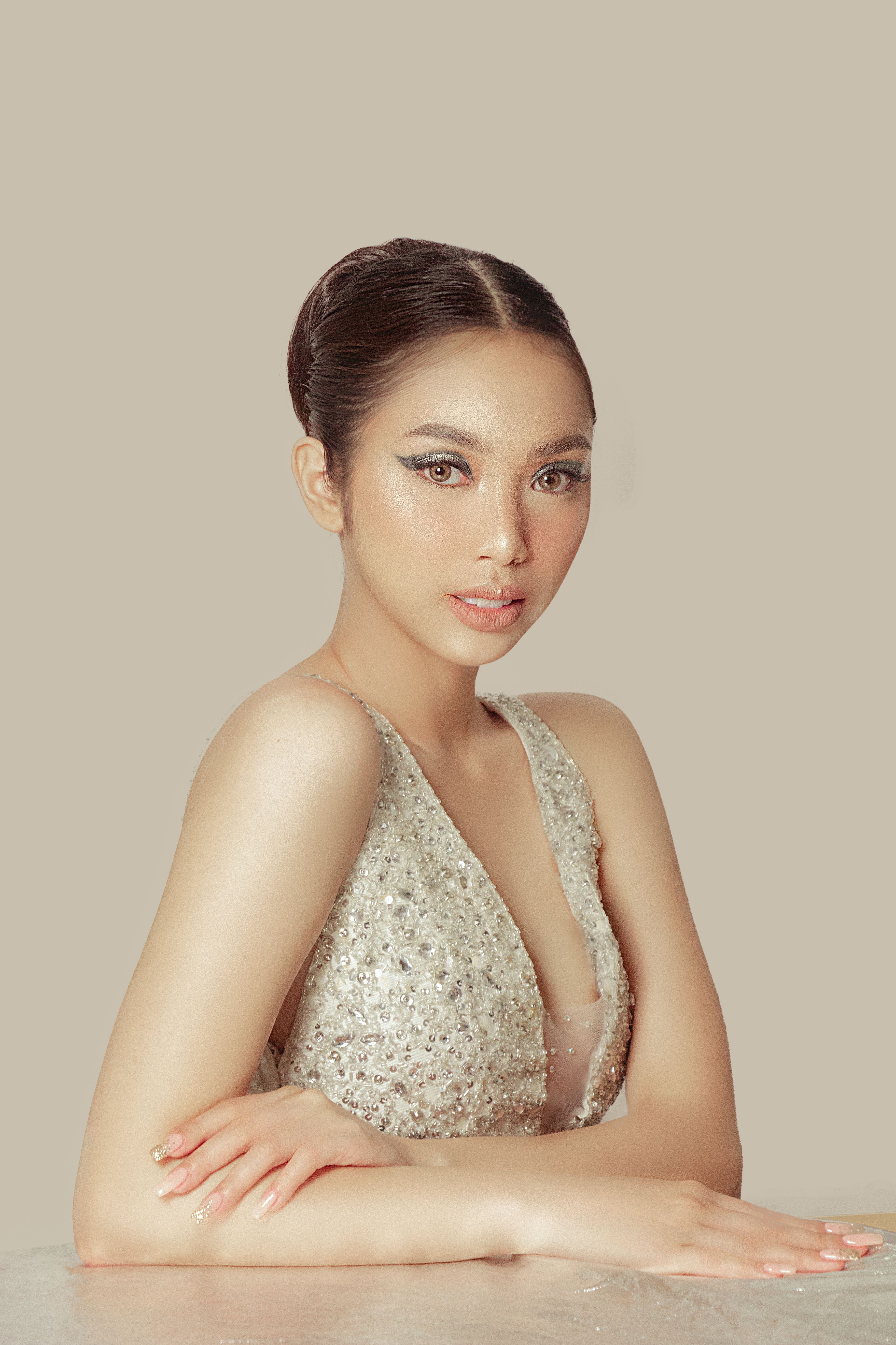 Portrait of a beautiful woman in a sparkling gown posing with elegance.