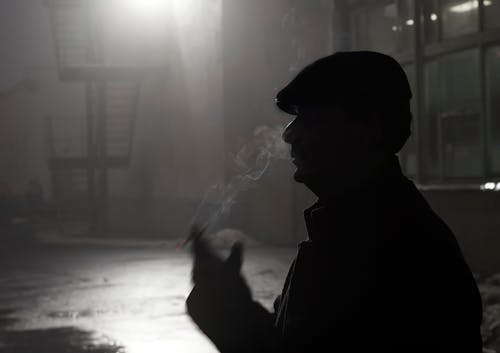 Silhouette of Man Smoking Cigarette