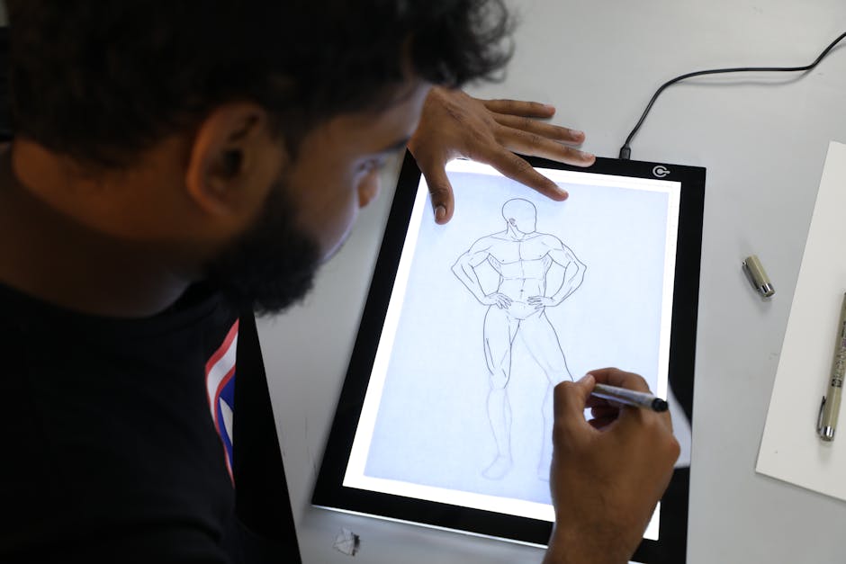 Illustrator sketching a superhero figure on a digital lightboard in an art studio setting.