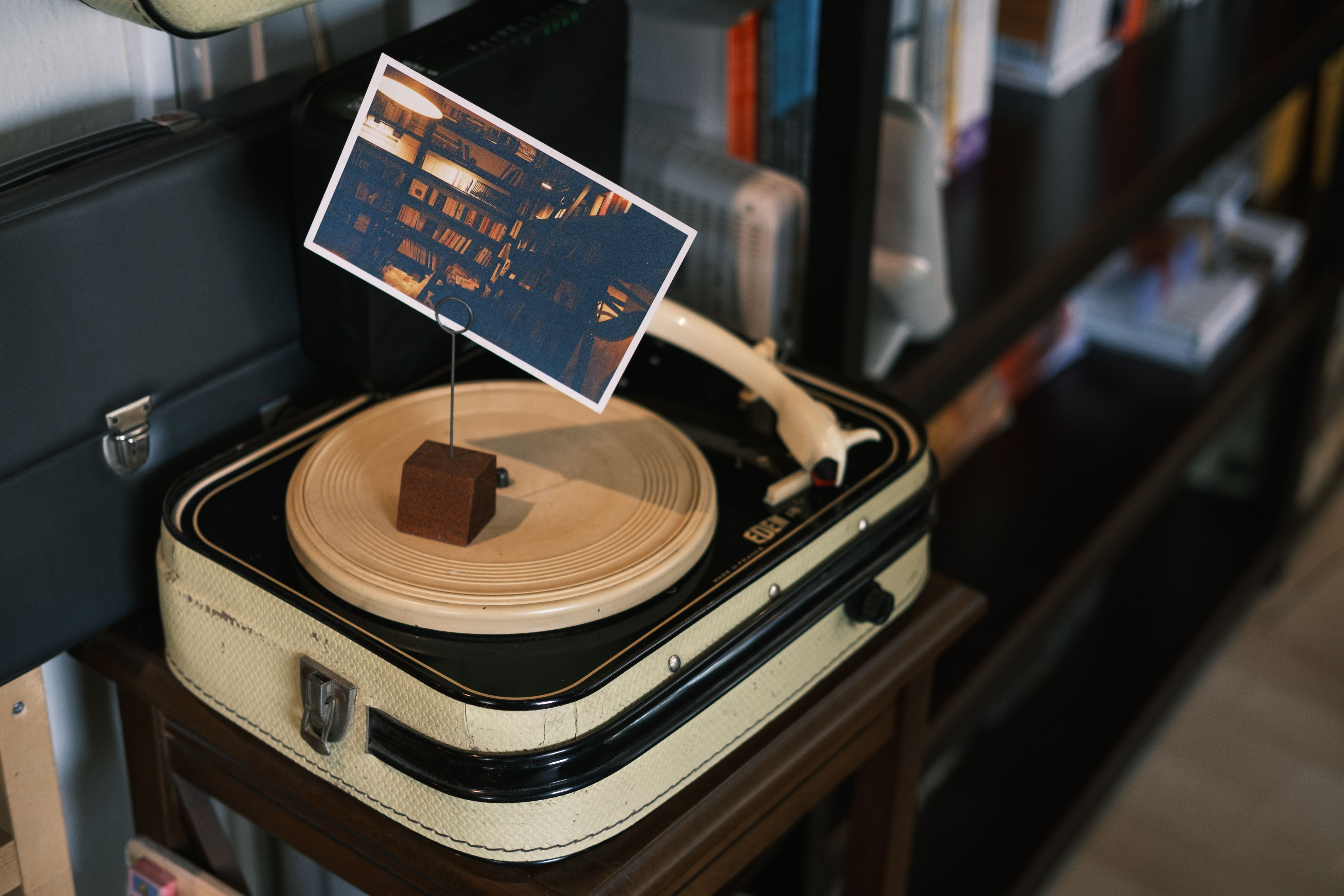 A stylish, modern bedroom setup with a turntable on a shelf, vinyl records displayed on the wall, creating a cozy aesthetic