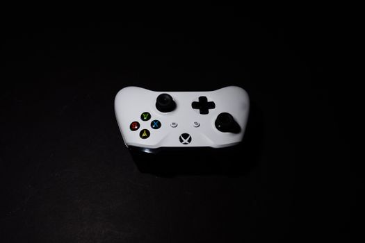 A close-up of a white Xbox controller on a black background, highlighting its modern design.
