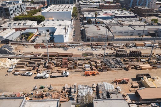 Aerial shot of an industrial construction site in an urban area, showcasing tools and materials.