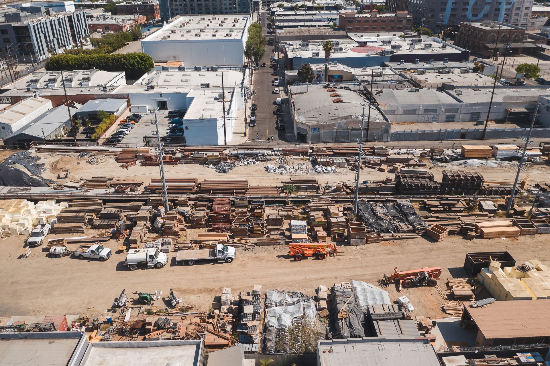 Aerial shot of an industrial construction site in an urban area, showcasing tools and materials.