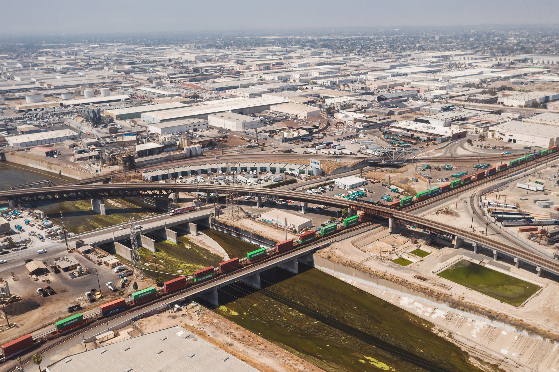 Drone shot of Los Angeles showcasing urban railways and expansive industrial area.