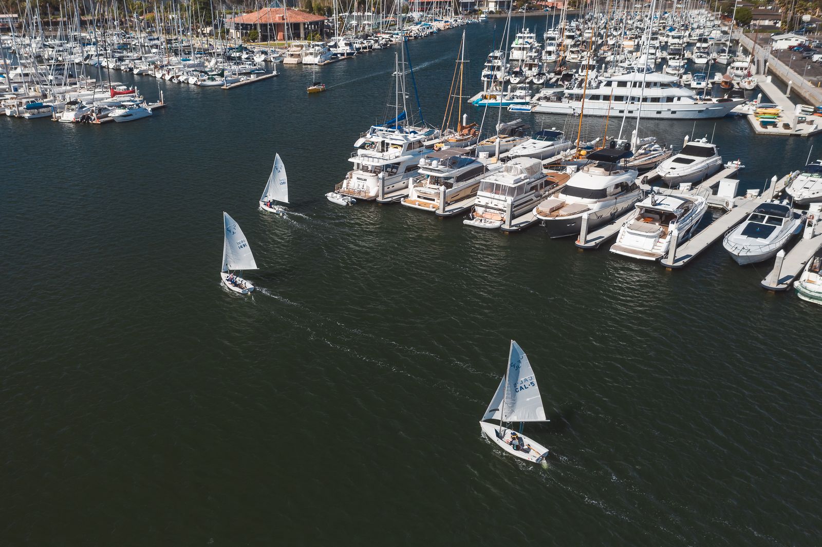 Aerial view of boats moored at the marina under sunny skies