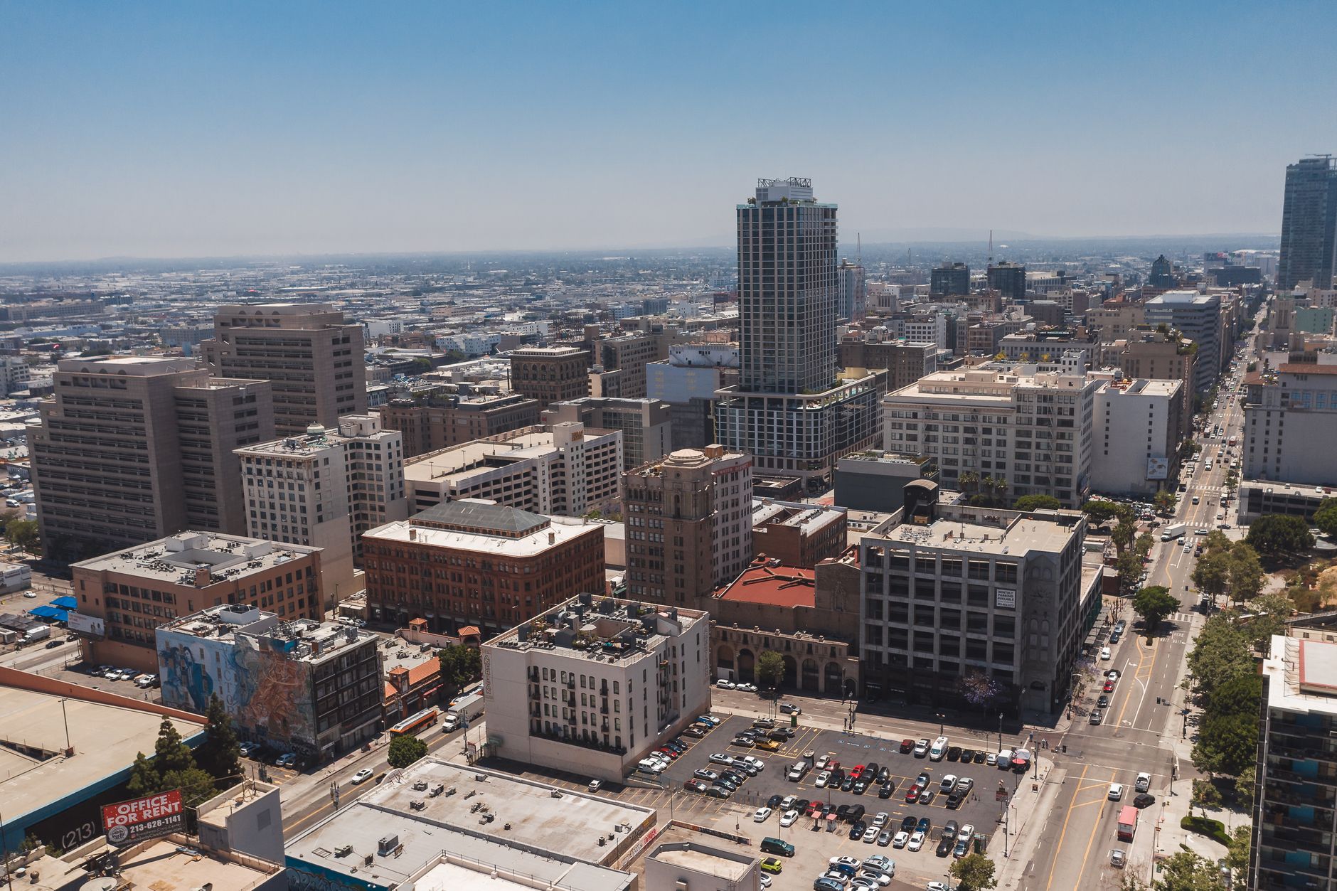 Panoramic aerial shot capturing downtown Los Angeles with skyscrapers and urban streets.