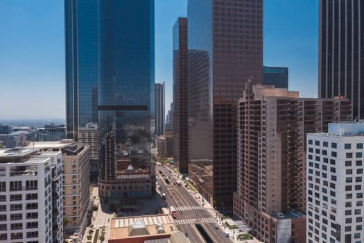Stunning aerial view of a modern cityscape with skyscrapers under a bright blue sky.