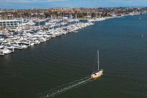 Yellow and White Sailboat on Body of Water