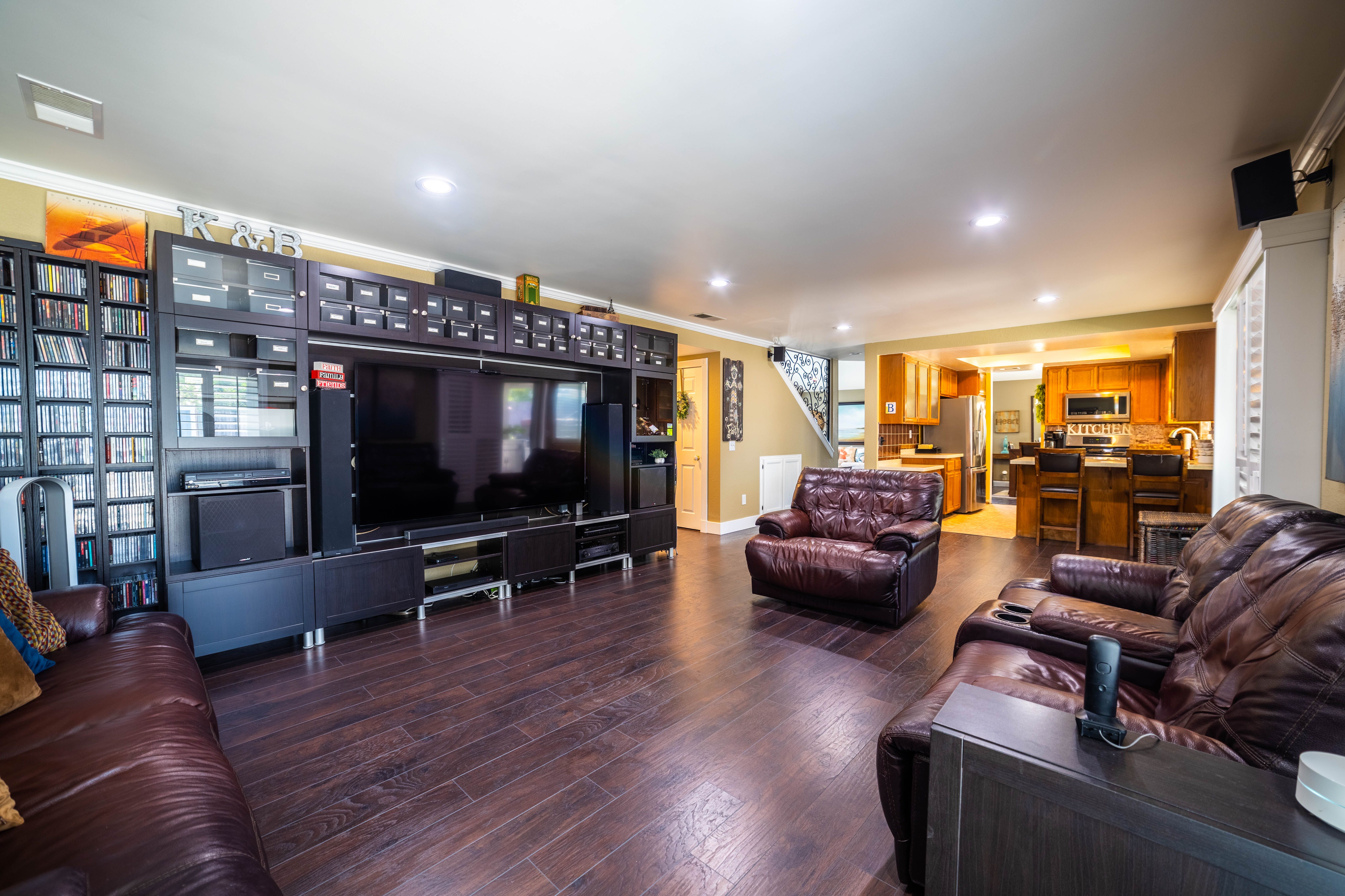 Spacious and modern living room featuring leather seating and wooden flooring. Ideal for interior design themes.
