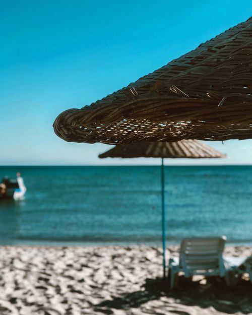 Free Peaceful beach with rattan umbrella and lounge chairs in Marmaraereğlisi, perfect for a summer getaway. Stock Photo