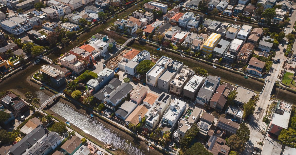 A scenic aerial shot showcasing a residential neighborhood with a canal running through it.