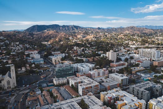 Aerial view of Los Angeles cityscape with mountains in the background on a clear day.